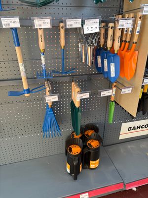 many different types of garden tools displayed on the wall