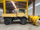 un gros camion jaune équipé d'une lame à neige