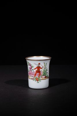 a white cup with a red and yellow design on it