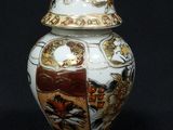 an image of a vase with a lid on a black background