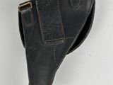 a close up of a leather holster on a white surface