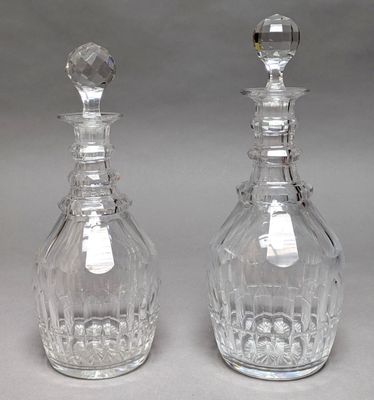 pair of crystal decanters with stoppers on each of them