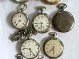 many different types of pocket watches on the table
