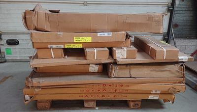 une pile de cartons posée sur une palette dans un garage