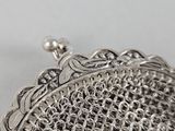 an image of a silver purse sitting on top of a table