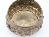 an old silver bowl with a decorative design on the inside of it