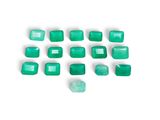 a group of emerald green rectangular cut stones on a white surface