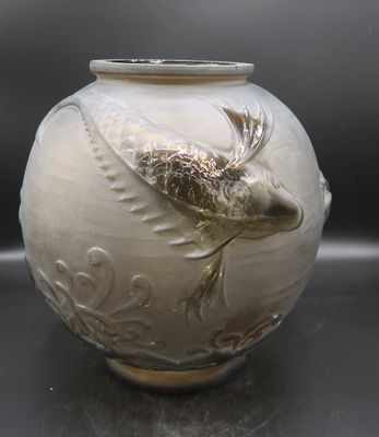 a white vase with a bird on it sitting on a table