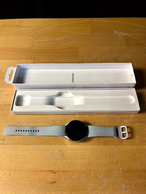 une montre connectée posée sur une table à côté d'une boîte
