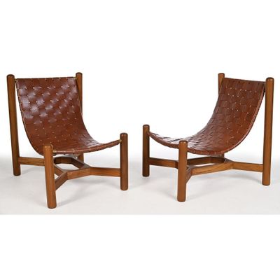 une paire de fauteuils de salon en cuir marron avec des pieds en bois