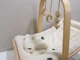 a wooden rocking chair with a white teddy bear on it