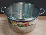 a large metal pot with a lid on a wooden table