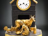 une horloge posée sur une table avec une vache dessus