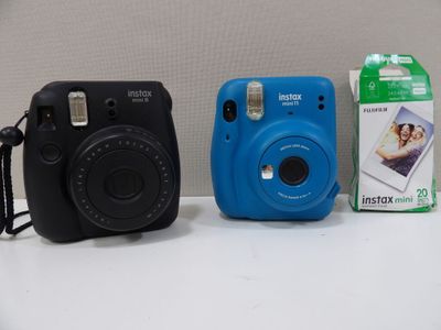 two cameras sitting next to each other on a table