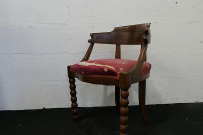 une chaise en bois sur laquelle est posé un coussin rouge