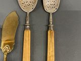 two spoons and a knife on a table next to each other