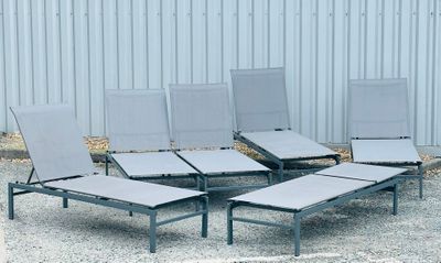 four lounge chairs that are sitting in the gravel