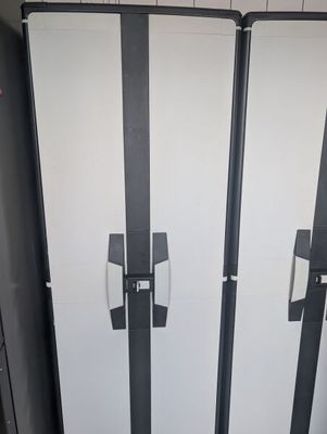three white refrigerators in a row in a public restroom