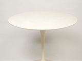 a white table with a round base and a white base