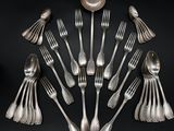 a lot of silver spoons and forks arranged in a circle