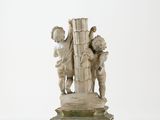statue of a boy and a girl holding a book on a pedestal