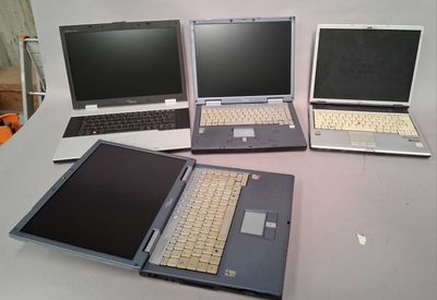 several laptops are lined up on a table in a row