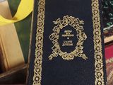 a person holding a book with a yellow ribbon around it