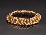 a close up of a gold bracelet on a black surface