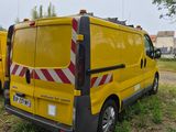 two yellow vans parked next to each other in a field