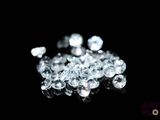 some white diamonds on a black surface with a black background