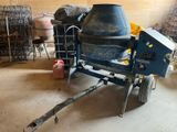 a cement mixer sitting in a garage next to a cart