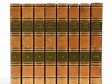 six vieux livres sont alignés sur une surface blanche