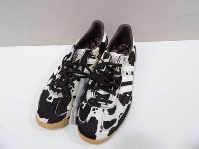 black and white cow print sneakers with laces on a white surface