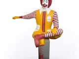 statue of ronald the clown sitting on a stool