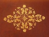 a gold design on a brown surface of a table