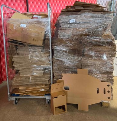 plein de cartons, les uns sur les autres, sur un chariot dans une pièce