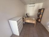 a white refrigerator sitting in the corner of a room next to a desk