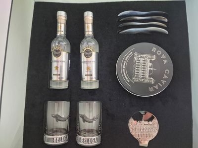 a display case with a bottle of alcohol, a knife, and other items