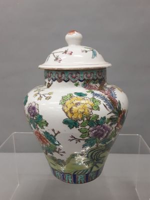 un vase muni d'un couvercle, exposé dans une vitrine