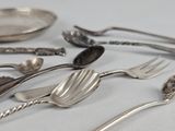 a lot of silver spoons, forks and spoons on the table