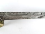 a close up of a sword on a white surface