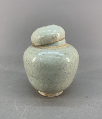a white vase with a lid sitting on a table