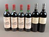 six bottles of red wine lined up in a row on a table