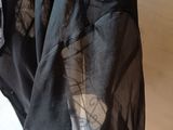 someone is holding a black shirt with a black and white design on it