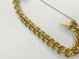 gold plated necklace with a lock on a chain on a white surface