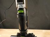 Quelqu'un utilise un aspirateur pour nettoyer une table en bois.