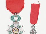 an image of a red ribbon with a star and a medal on it