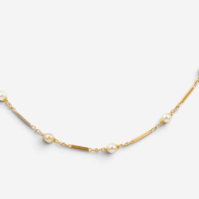 un collier en or orné de perles sur fond blanc