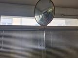 un miroir accroché au mur au-dessus d'une fenêtre dans une salle de bains