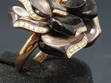 an image of a black and gold rose ring on a black surface